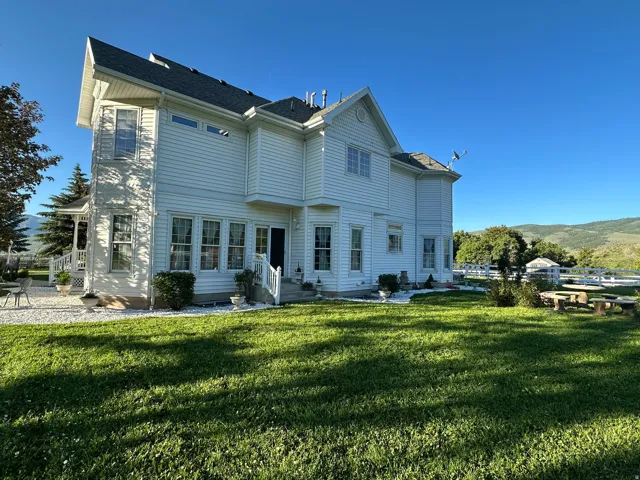 Expansive rear facade featuring white siding and a multi-level roofline