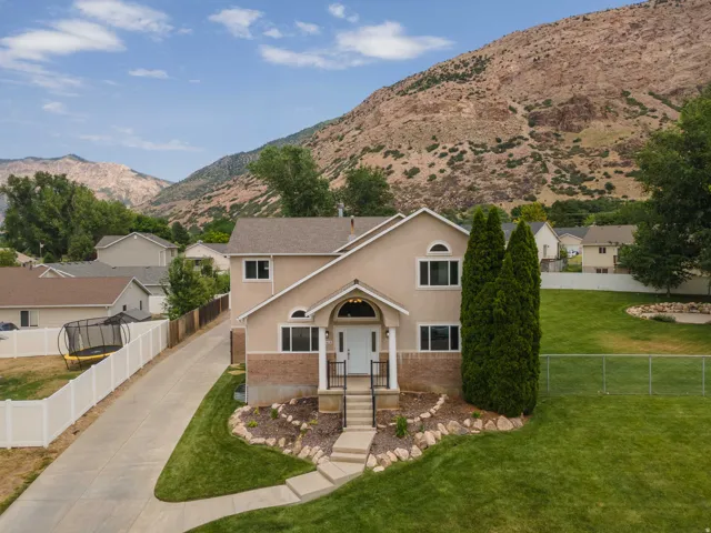 Two-story home with a tan stucco exterior and stone accents