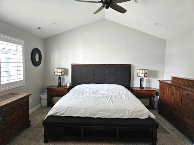 Vaulted ceiling bedroom featuring a ceiling fan, recessed lighting, and plantation shutters
