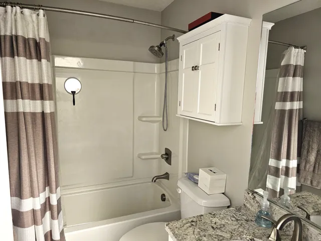 Tub/shower combination featuring a rainfall showerhead and integrated shelving