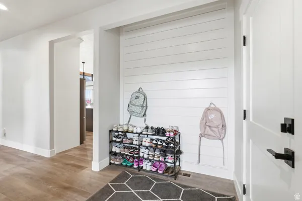 Entryway featuring white shiplap wall paneling and wood-finish flooring