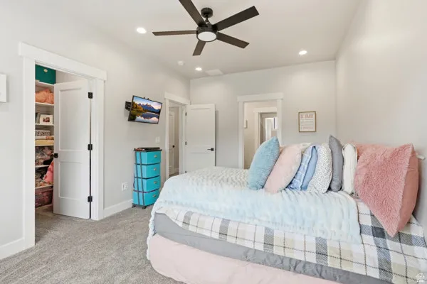 Carpeted interior space featuring a ceiling fan with light, recessed lighting, and white trim
