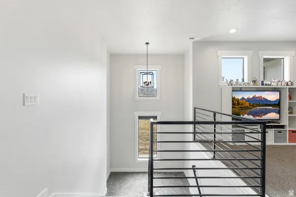 Modern interior featuring a black metal horizontal railing, white painted walls, and recessed lighting