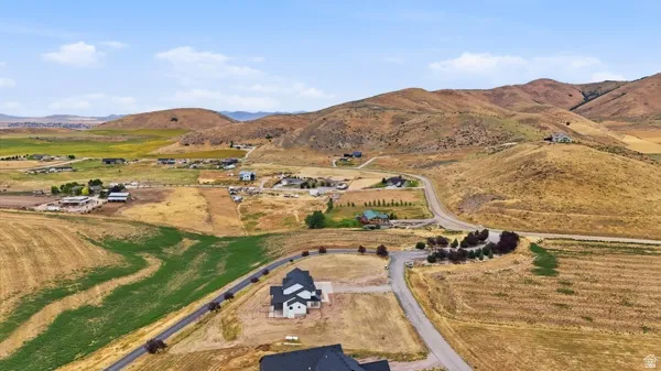 Expansive rural landscape featuring rolling hills, varied topography, and distant structures
