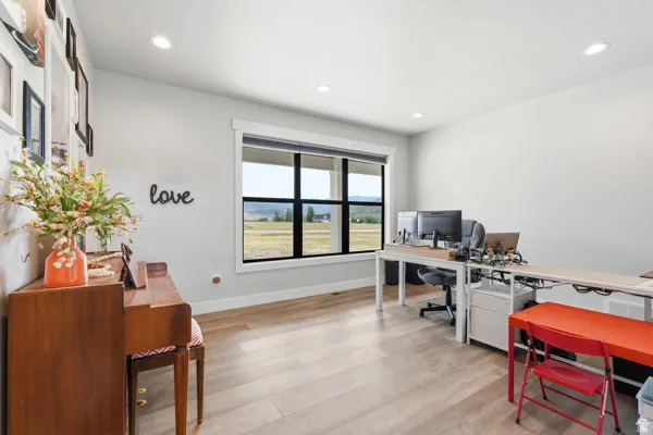 Spacious room featuring light wood-finish flooring and recessed lighting