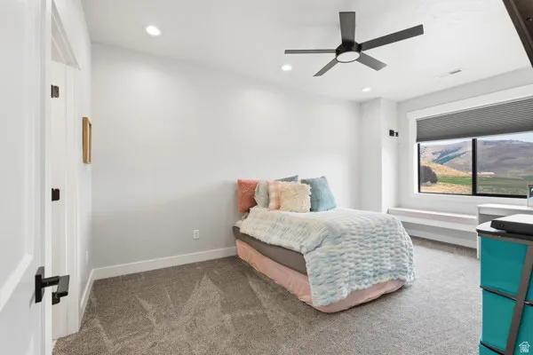 Bedroom featuring recessed lighting, a ceiling fan with integrated lighting, window with mountain scenery, and a built-in window bench