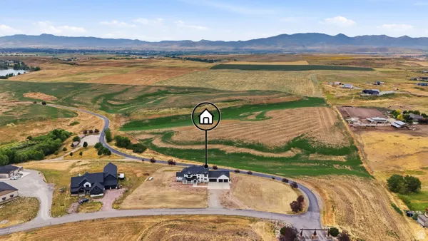 Aerial perspective highlighting the property's expansive land, distant mountain range, and nearby body of water