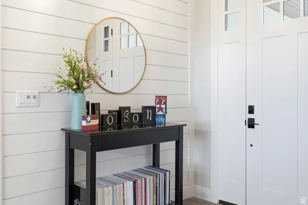 Entryway featuring white shiplap walls, a solid panel door with upper glass inserts, and matte black hardware