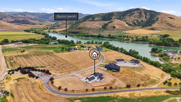 Elevated lot with distant water feature, surrounded by natural landscapes and developed properties