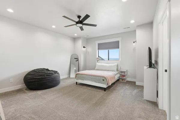 Spacious room featuring neutral carpeting, recessed lighting, and a modern ceiling fan