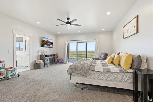 Spacious room featuring light gray carpeting, recessed lighting, and a modern ceiling fan