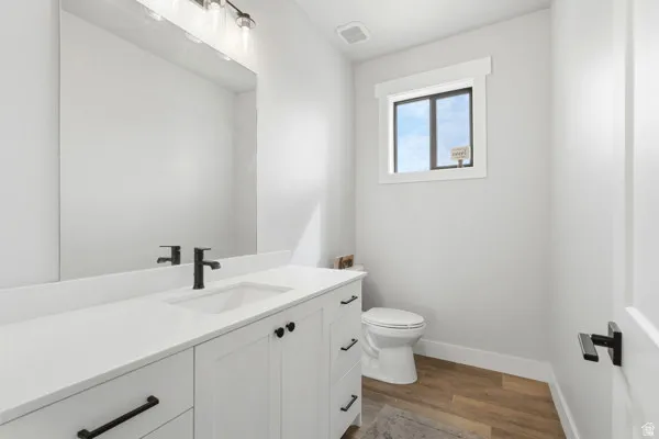 Bathroom vanity featuring a white countertop, undermount sink, and matte black faucet