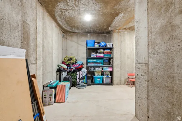 Unfinished concrete basement area featuring a concrete floor, concrete walls, and overhead lighting