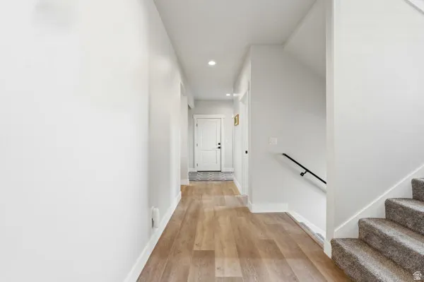 Light wood-finish flooring extending through the hallway