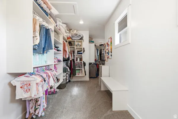 Custom closet system with multiple shelving units, hanging rods, and built-in bench