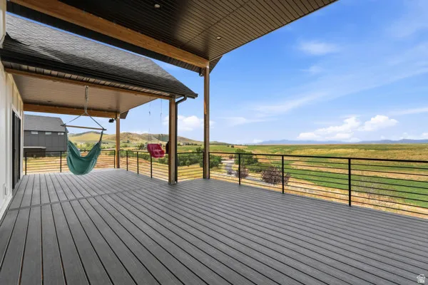 Expansive outdoor deck featuring composite decking, a protective overhead covering, and a horizontal bar railing system