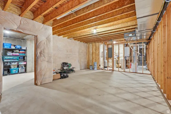 Unfinished basement with exposed ceiling joists and concrete flooring