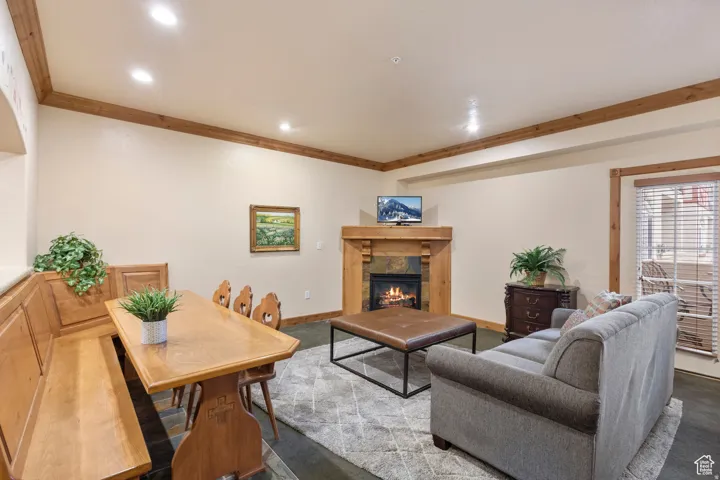 Living area featuring a stone-clad fireplace with wood mantel, recessed lighting, and wood-finish flooring
