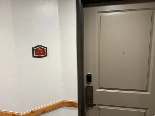 Entry door with smart lock system, brass hardware, and paneled design