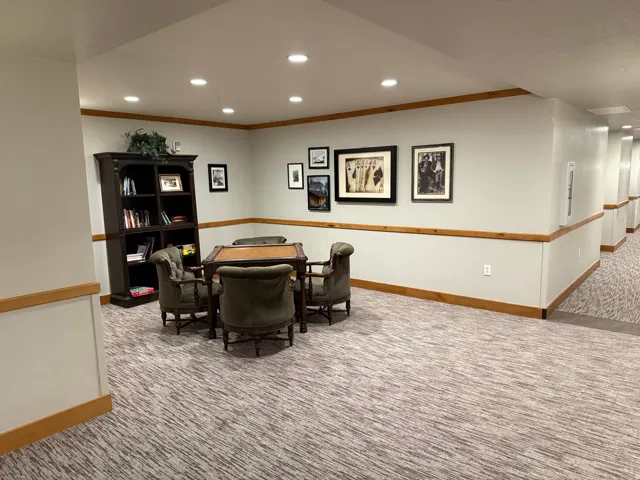 Carpeted common area featuring recessed lighting, light-toned wall paint, and natural wood trim accents