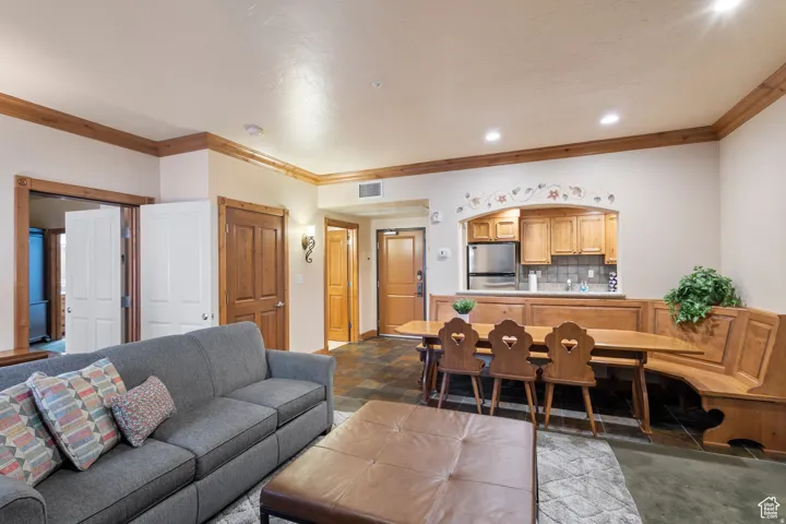 Open-concept living area featuring wood-finish trim, durable tile flooring in the kitchen and entryway, and a built-in dining nook
