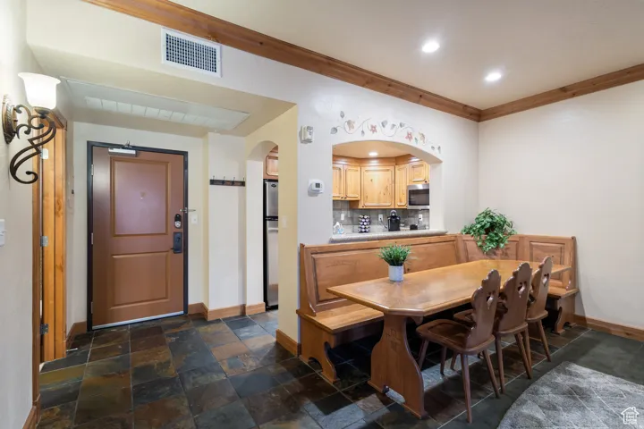 Entry area with slate tile flooring and a decorative wall sconce