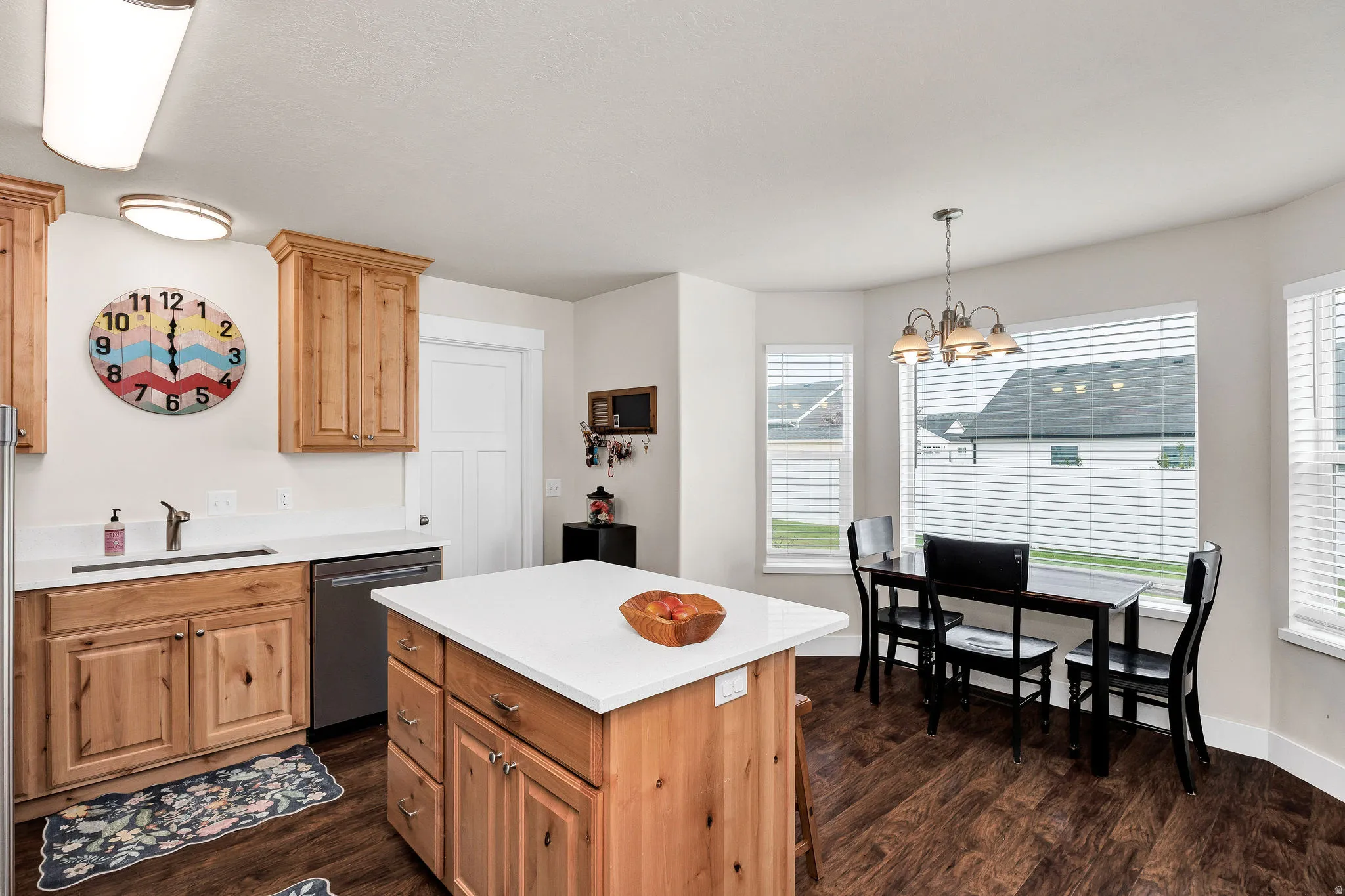Kitchen featuring wood cabinetry, white countertops, and wood-finish flooring