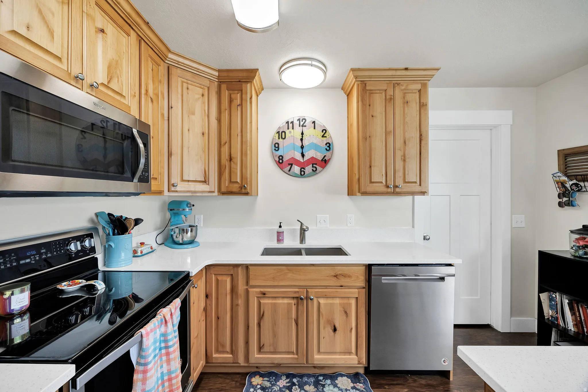 Kitchen featuring wood cabinetry, white countertops, stainless steel appliances, and a double basin sink