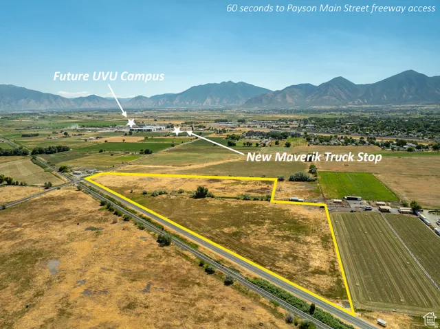 Expansive undeveloped land featuring a clear perimeter, adjacent roadway access, and mountain scenery
