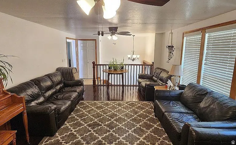 Living area featuring wood-finish flooring, white walls, and wood trim around windows