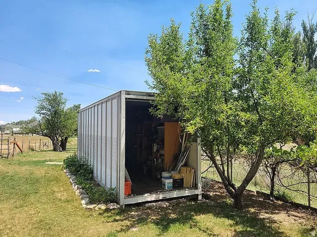Storage container with open access, positioned on a grassy expanse