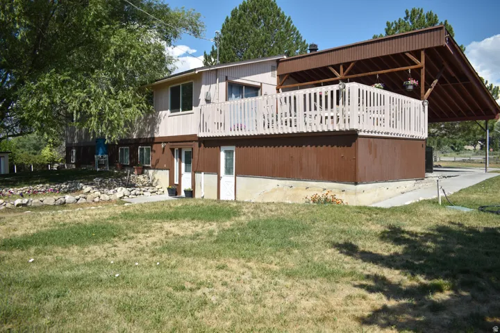 Multi-level residence featuring a prominent covered deck with white railing