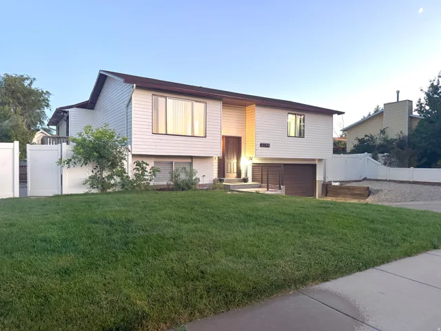 Split-level residence featuring white siding and brown trim