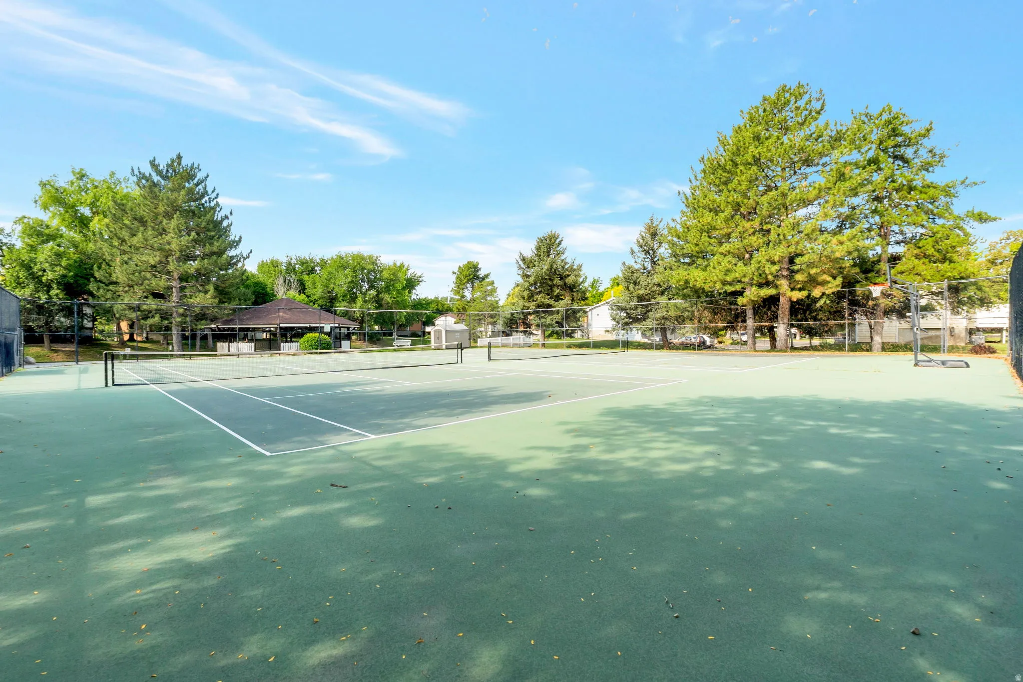 Two hard surface tennis courts with green playing areas and white boundary lines