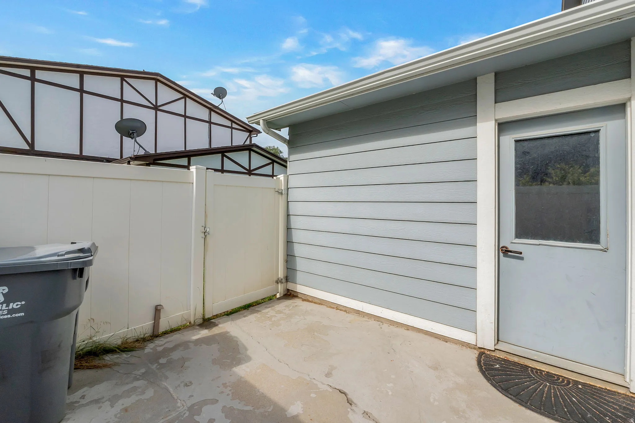 Exterior featuring horizontal siding, white trim, and a utility door with a window
