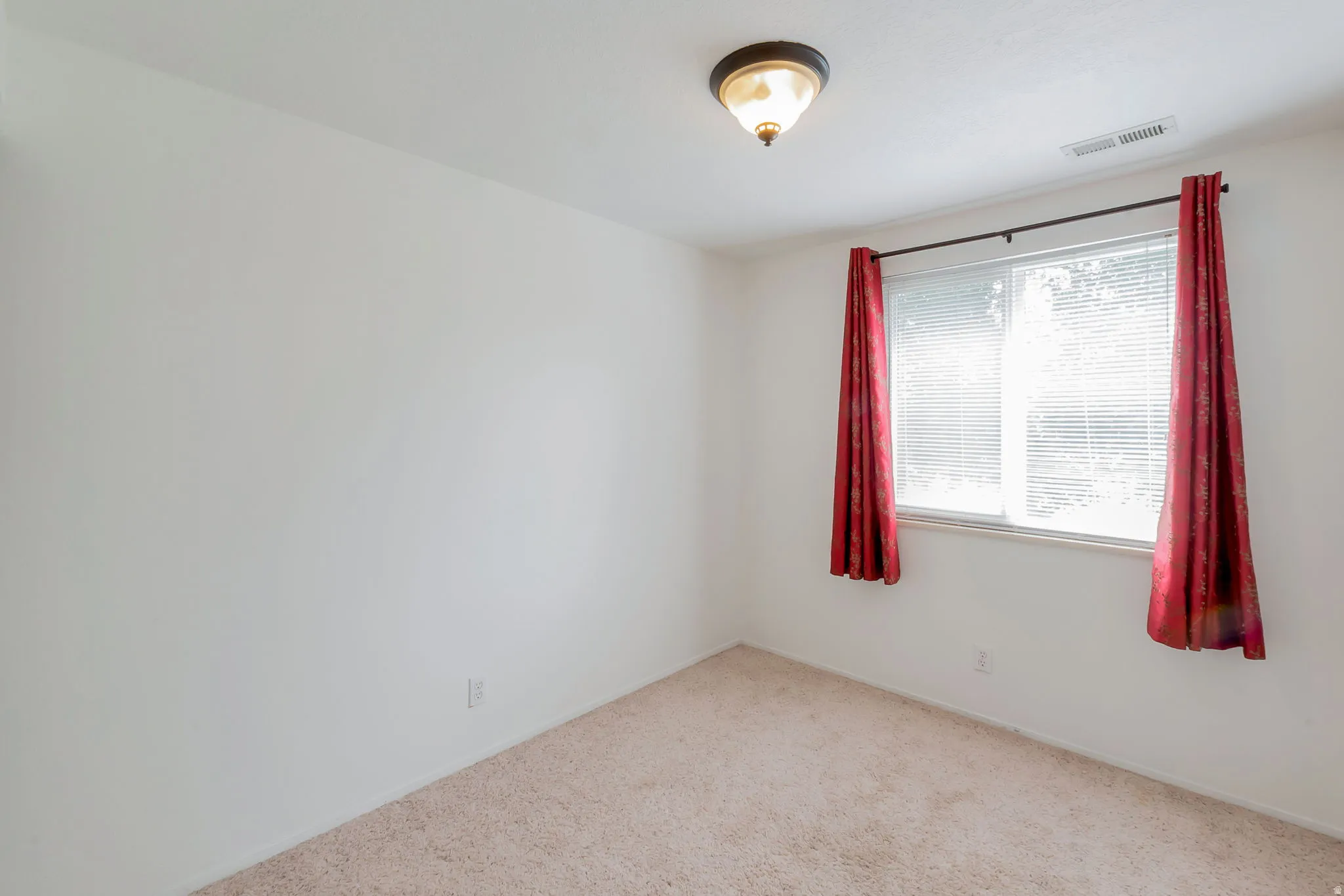 Neutral wall finishes with a window featuring blinds and a ceiling-mounted light fixture