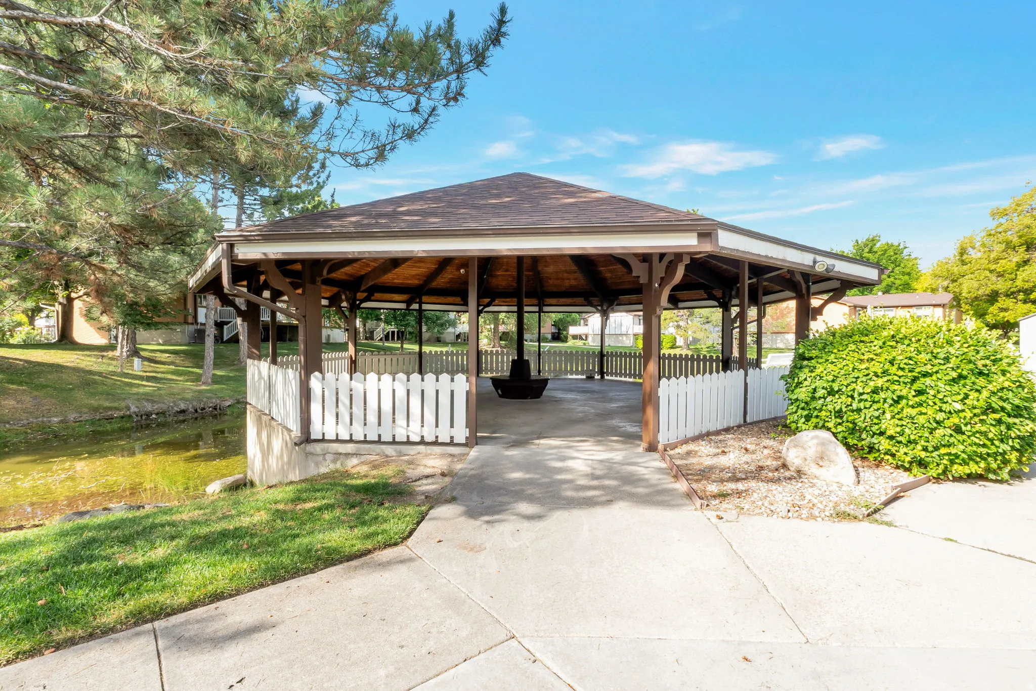 Expansive octagonal gazebo featuring a shingle roof and open-beam wood-finish ceiling