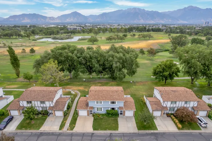 Aerial perspective showcasing multiple two-story homes with attached garages, light brown shingle roofs, and paved driveways
