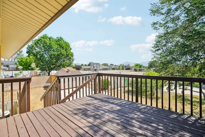 Spacious wood deck with dark stained railing, offering an elevated perspective