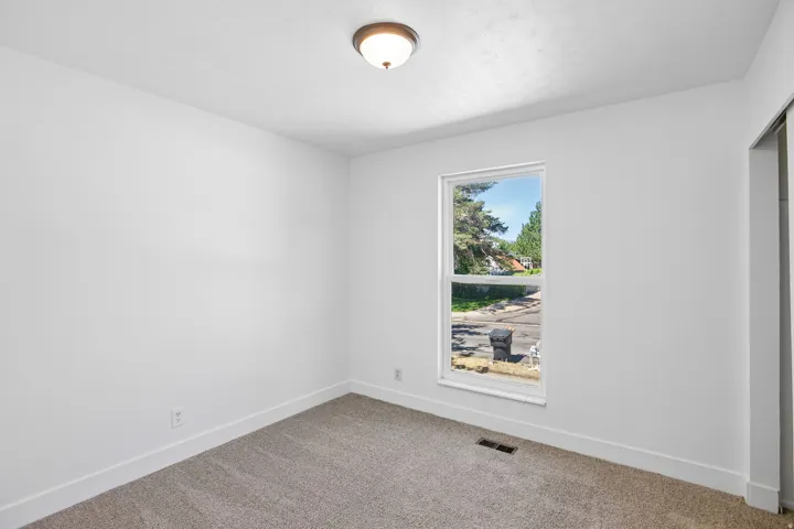Neutral white walls with a single window providing natural illumination