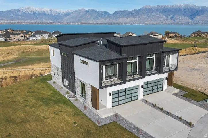 Modern exterior featuring a dark gray roof, vertical dark siding, light gray siding, and stone accents