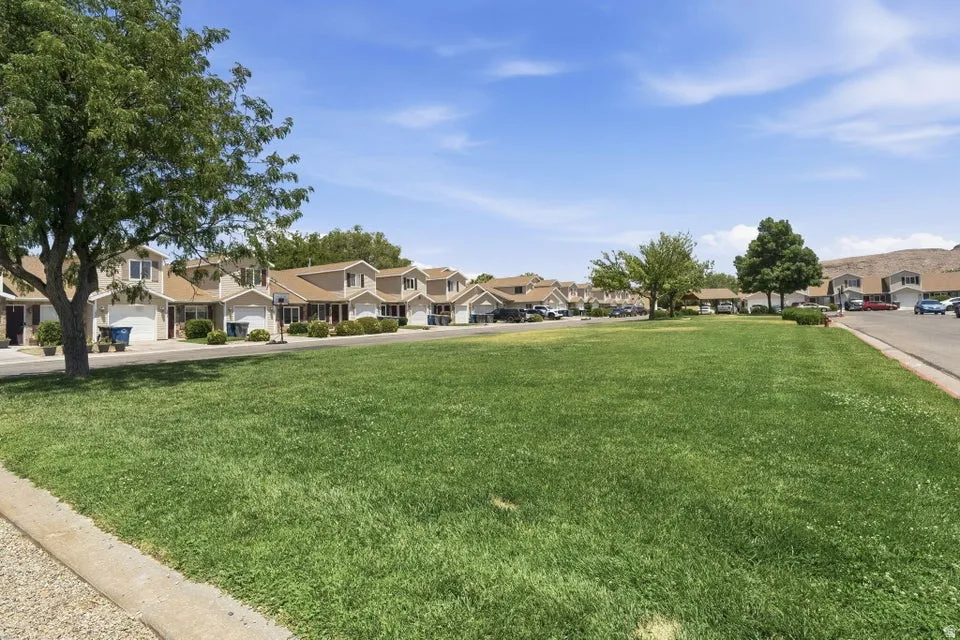 Expansive green space featuring a large lawn area and mature trees