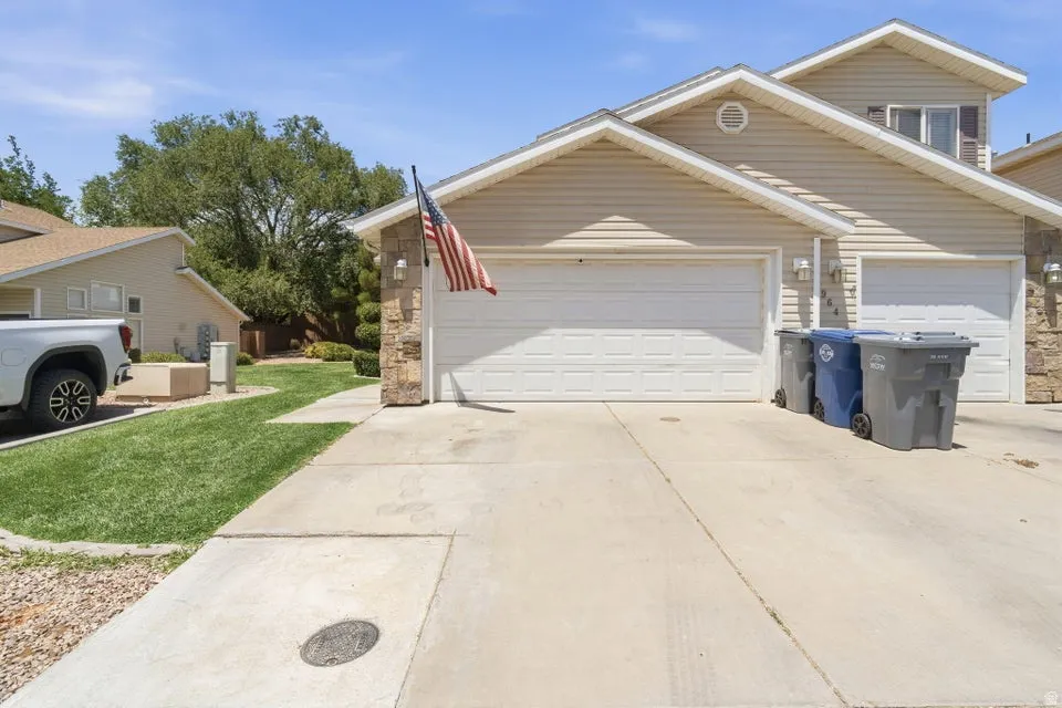 Exterior featuring a two-car garage, stone facade accents, and horizontal siding