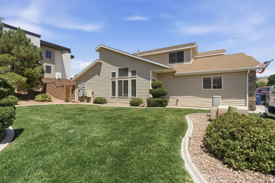 Exterior featuring beige siding, multiple windows, and a brown shingle roof