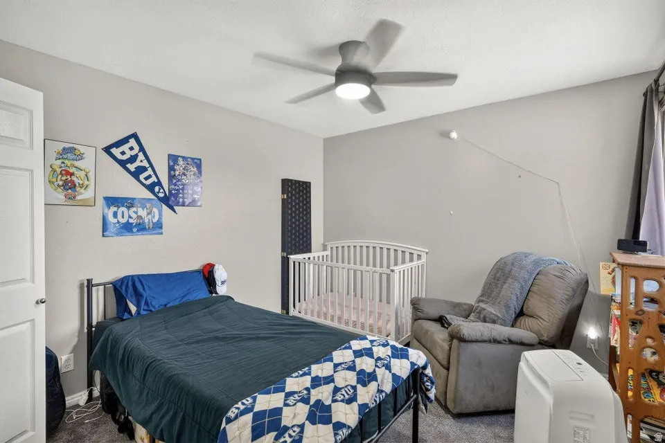 Bedroom featuring light gray walls, textured ceiling, and dark gray carpet flooring