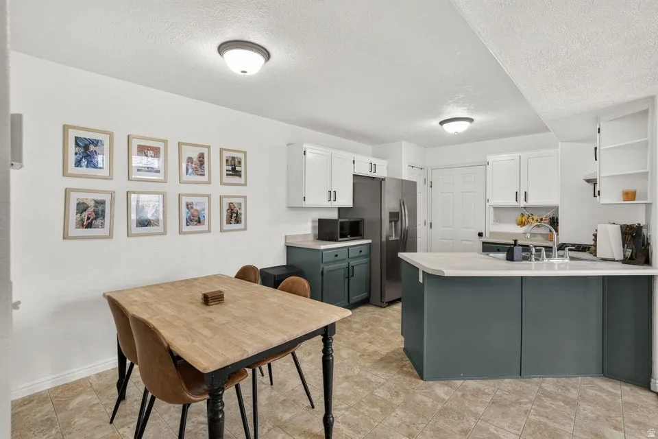 Well-appointed kitchen featuring a double basin sink, stainless steel refrigerator, and ample cabinetry with contrasting colors