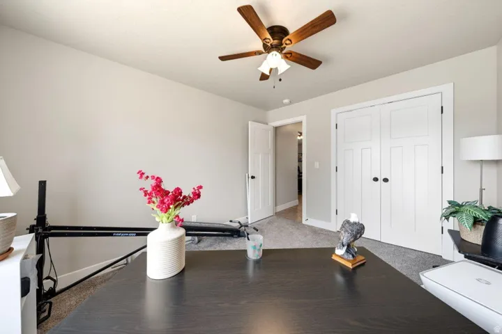 Carpeted room with a vaulted ceiling and a ceiling fan