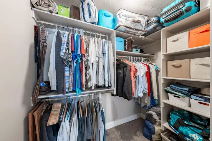 Custom closet organization system featuring white shelving and hanging rods