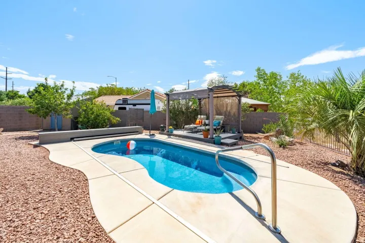 Kidney-shaped inground pool with integrated steps and a metal handrail