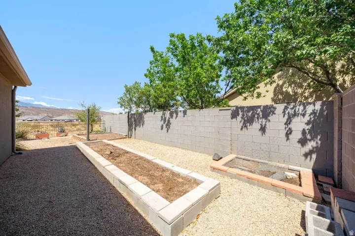 Expansive gravel yard featuring concrete block raised garden beds